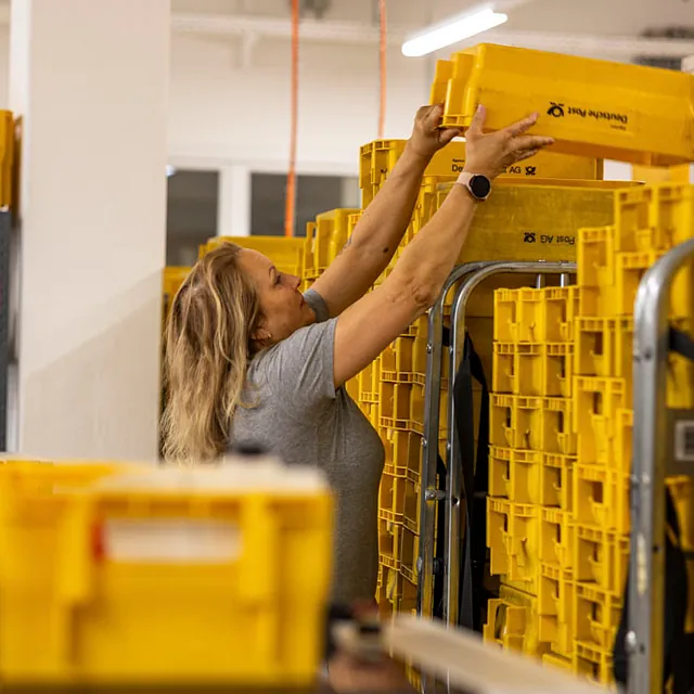 Frau stapelt gelbe Boxen
