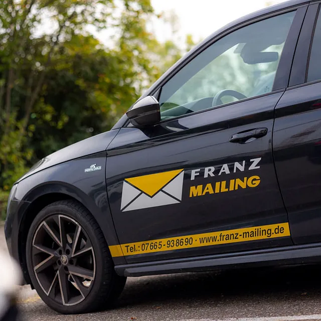 blaues Auto mit Briefumschlag drauf